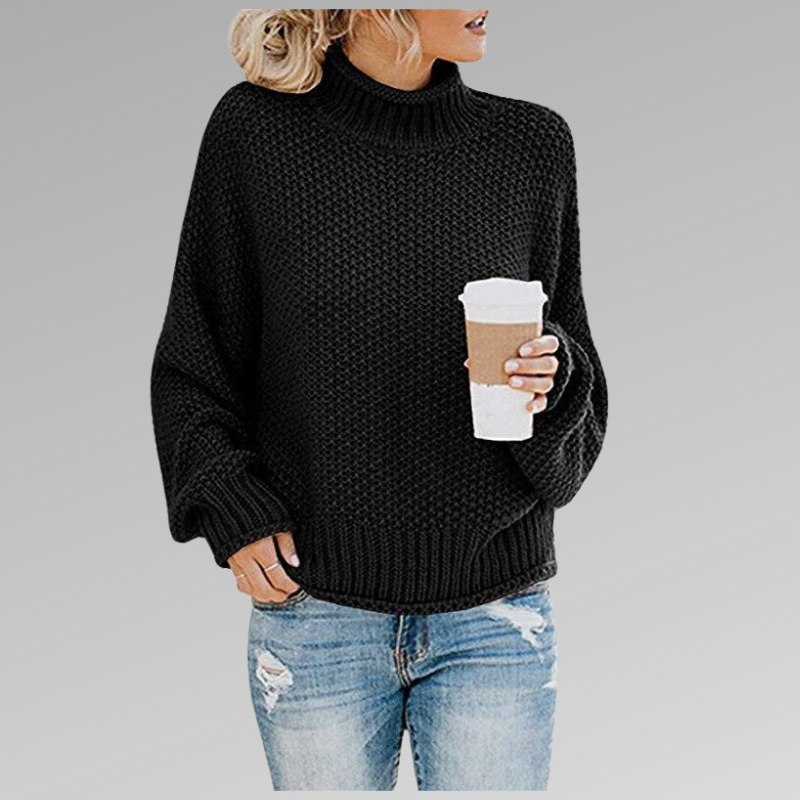 Frau in schwarzem Strickpullover mit Kaffeebecher, trägt zerrissene Jeans. Modetrend Herbst, lässiger Look, gemütlicher Stil.