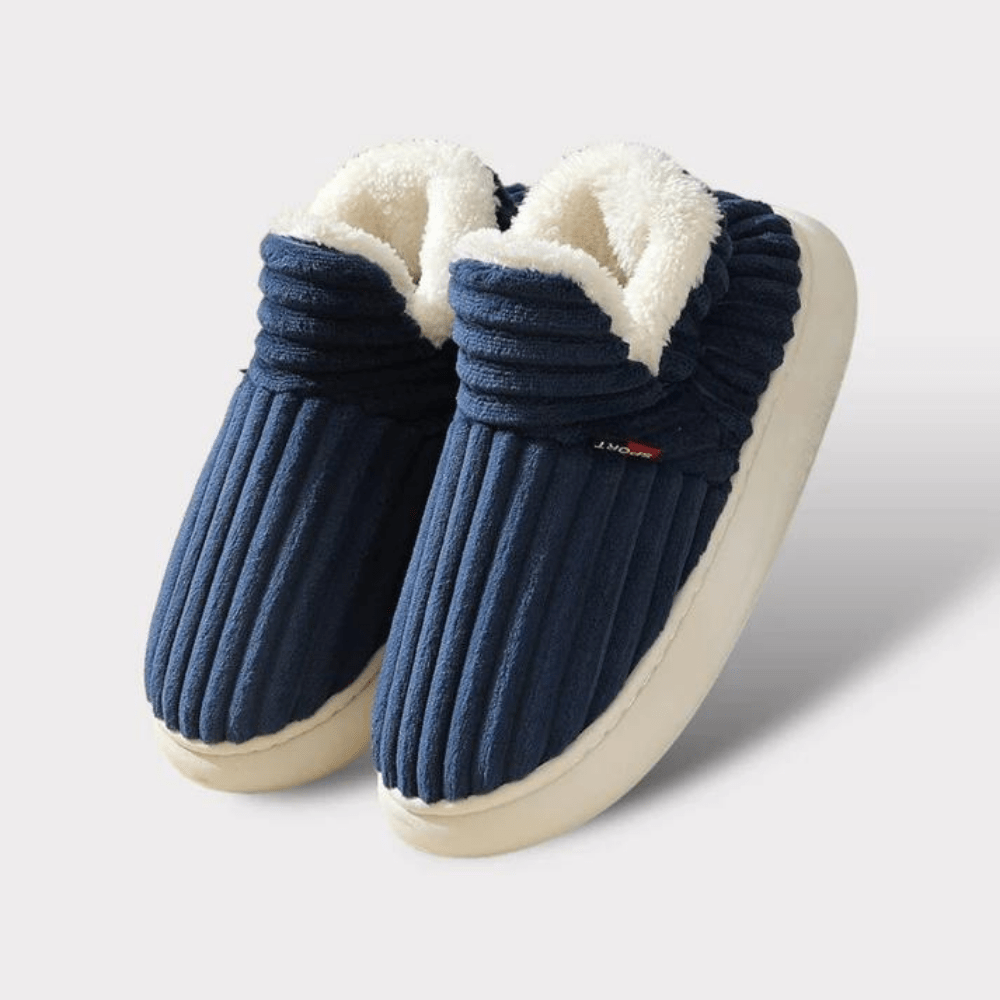 Blaue, gefütterte Hausschuhe mit gerippter Textur und weißem Plüschfutter, ideal für warme Füße im Winter. Bequeme, rutschfeste Sohle.