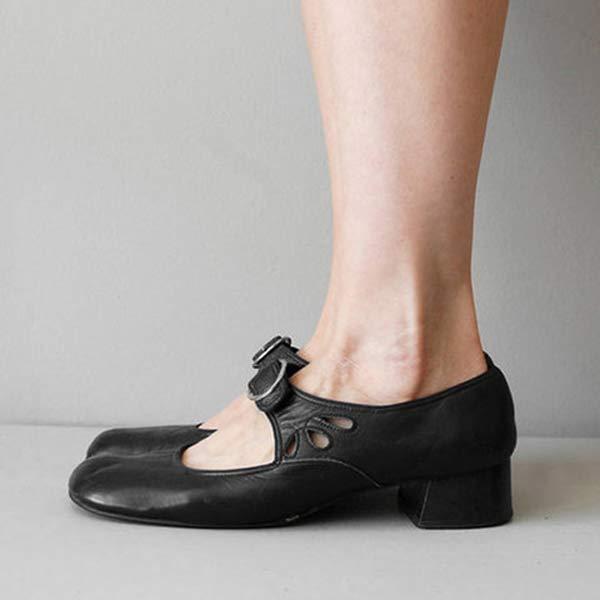 Schwarze Mary Jane Schuhe mit niedrigem Absatz und Schnallenverschluss an einem Fuß, seitliche Aussparungen, elegantes Design, Damenmode.