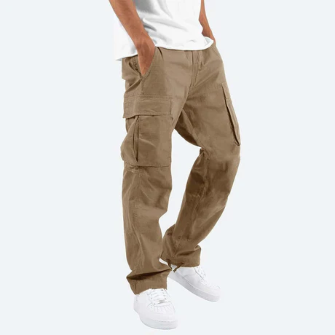 Mann trägt beige Cargohose mit Seitentaschen, kombiniert mit weißen Sneakers und weißem T-Shirt. Modische Freizeitkleidung für Herren.