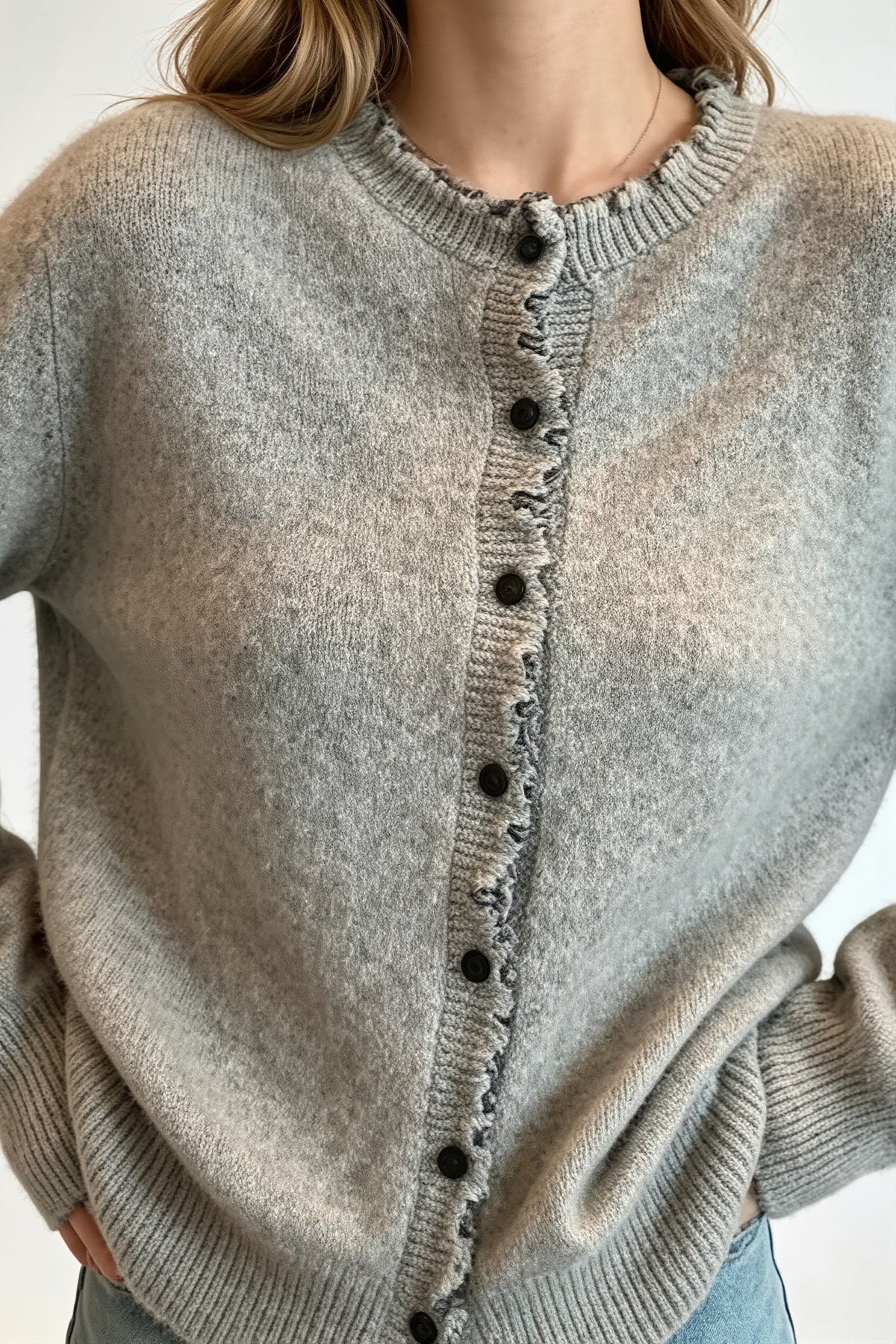 Nahaufnahme der Wellenborte und Knöpfe am Damen-Cardigan