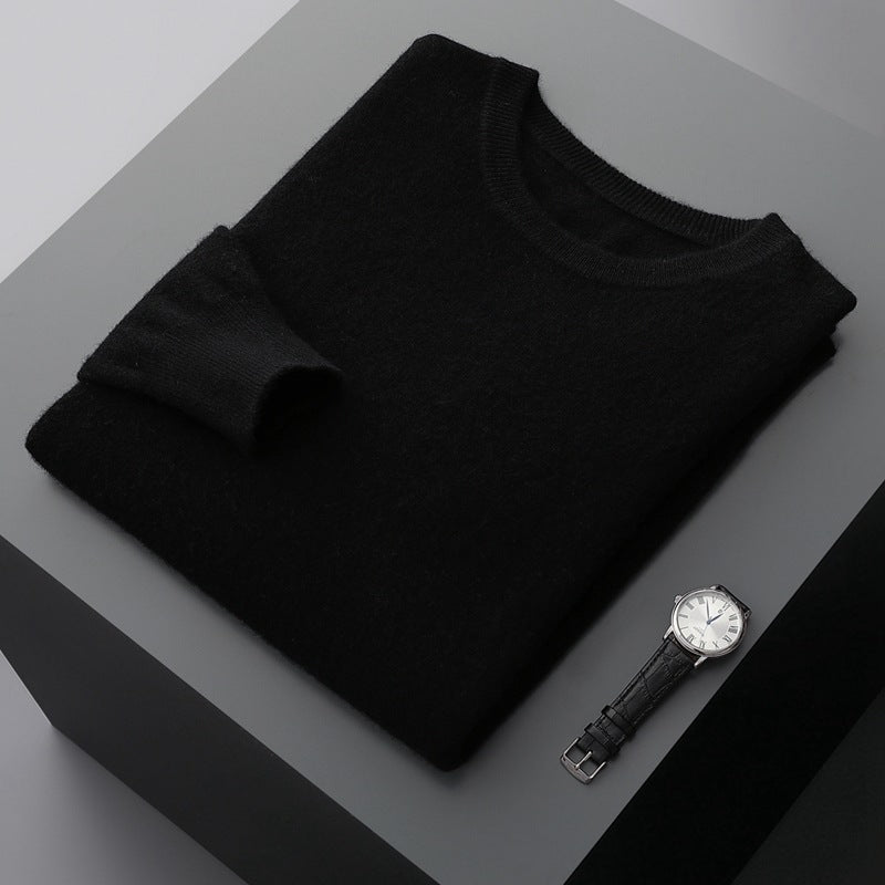 Schwarzer Pullover aus Kaschmir auf grauem Tisch, daneben eine elegante Armbanduhr. Luxuriöse Mode, stilvolle Accessoires, minimalistisches Design.