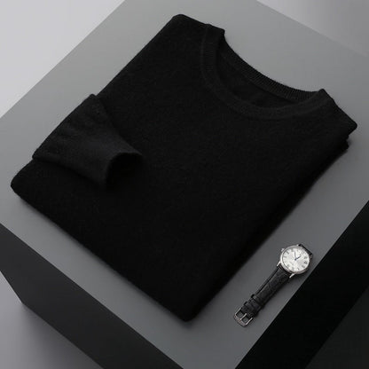 Schwarzer Pullover aus Kaschmir auf grauem Tisch, daneben eine elegante Armbanduhr. Luxuriöse Mode, stilvolle Accessoires, minimalistisches Design.