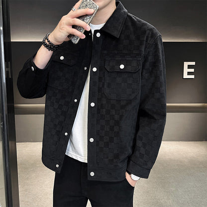 Mann in schwarzer karierter Jacke, hält Smartphone. Modische Herrenjacke, Freizeitlook, trendige Oberbekleidung, stilvolles Design.