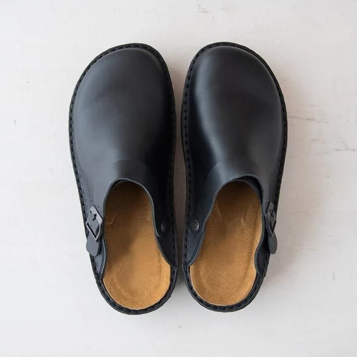 Schwarze Ledersandalen mit Schnalle, minimalistisch und modern, auf hellem Hintergrund. Bequeme, stilvolle Schuhe für Alltag und Freizeit.