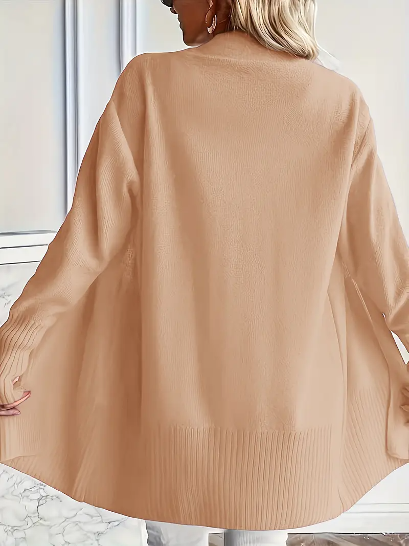 Frau trägt beige Strickjacke, Rückansicht. Modetrend Herbst, Damenmode, lässiger Stil, bequeme Oberbekleidung, elegantes Design.