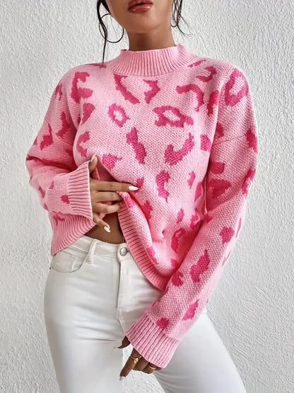 Frau in rosa Leopardenmuster-Pullover und weißen Jeans vor weißer Wand. Modetrend, Damenmode, stylischer Look, Herbstmode.