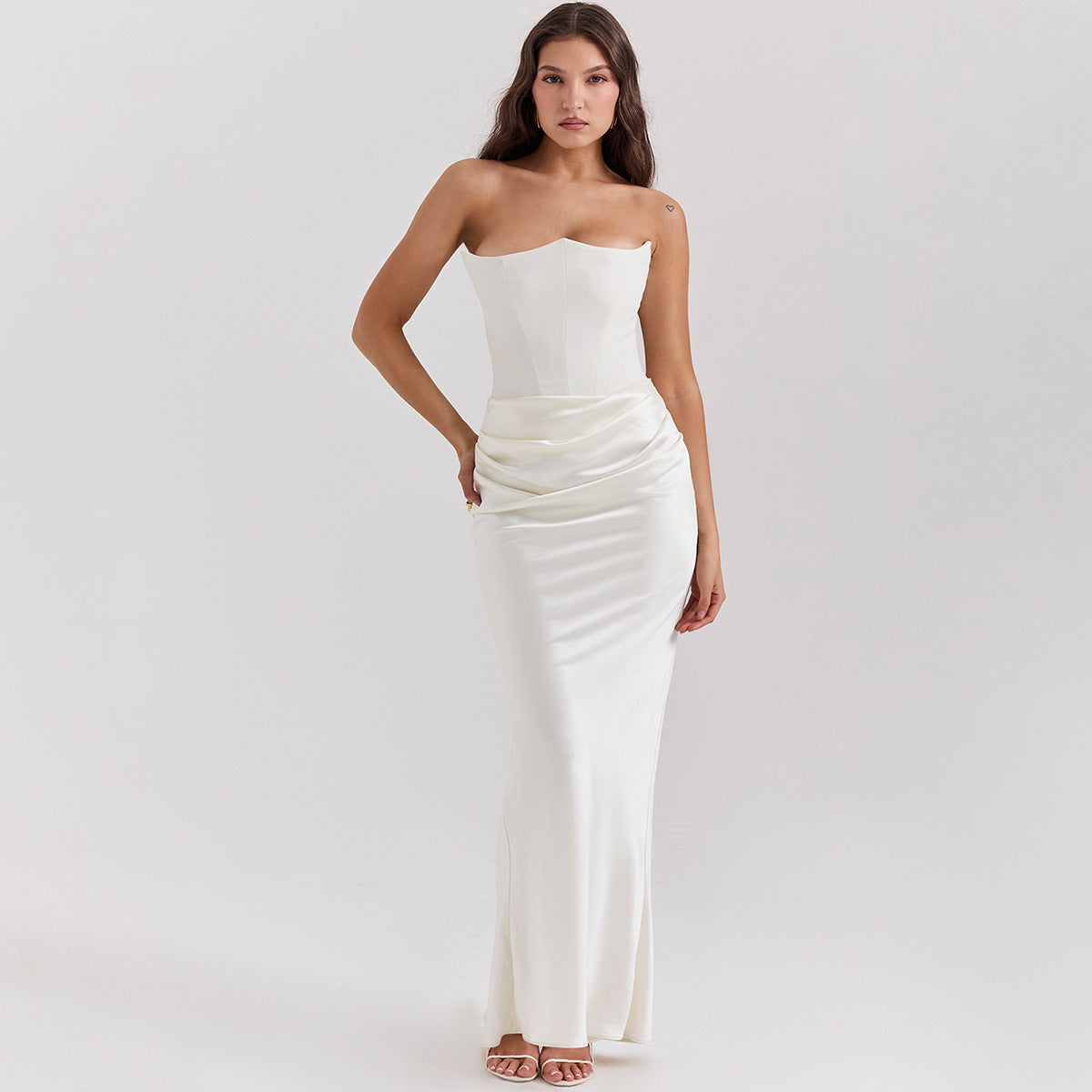 Frau in elegantem, schulterfreiem weißen Abendkleid, figurbetont und bodenlang, ideal für formelle Anlässe. Eleganz, Mode, Abendgarderobe.