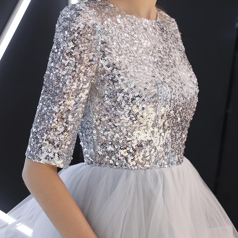 Silbernes Paillettenkleid mit halblangen Ärmeln und Tüllrock, elegantes Abendkleid, glamouröse Mode, festliche Damenbekleidung.