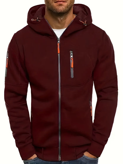 Mann in dunkelroter Kapuzenjacke mit Reißverschlüssen, lässiger Stil, modische Herrenbekleidung, Herbstmode, Outdoor-Jacke.
