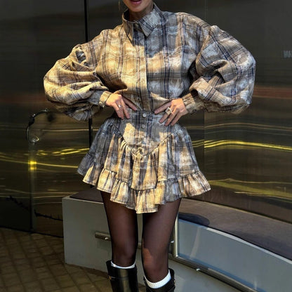 Frau in kariertem Kleid mit Puffärmeln und Rüschenrock, trägt schwarze Stiefel. Modetrend, Herbstmode, eleganter Look.