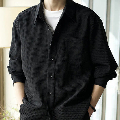 Schwarzes Herrenhemd mit Textur, lässig über weißem T-Shirt getragen. Modetrend, stilvoll, modern, ideal für Freizeit- und Alltagsoutfits.