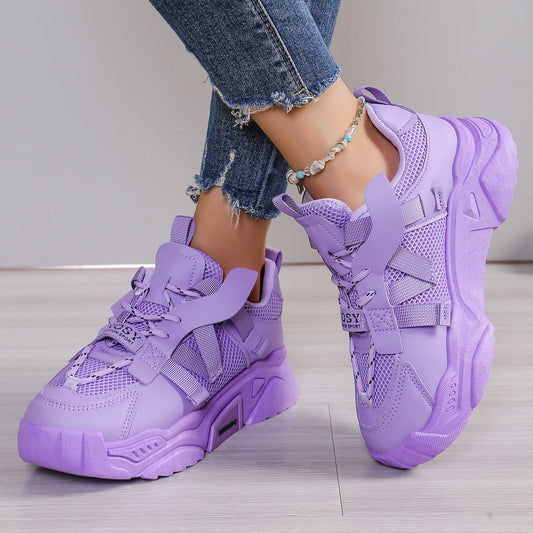 Lila Damen-Sneaker mit dicker Sohle, getragen mit Jeans. Modische Sportschuhe, trendiges Design, ideal für Freizeit und Streetwear.