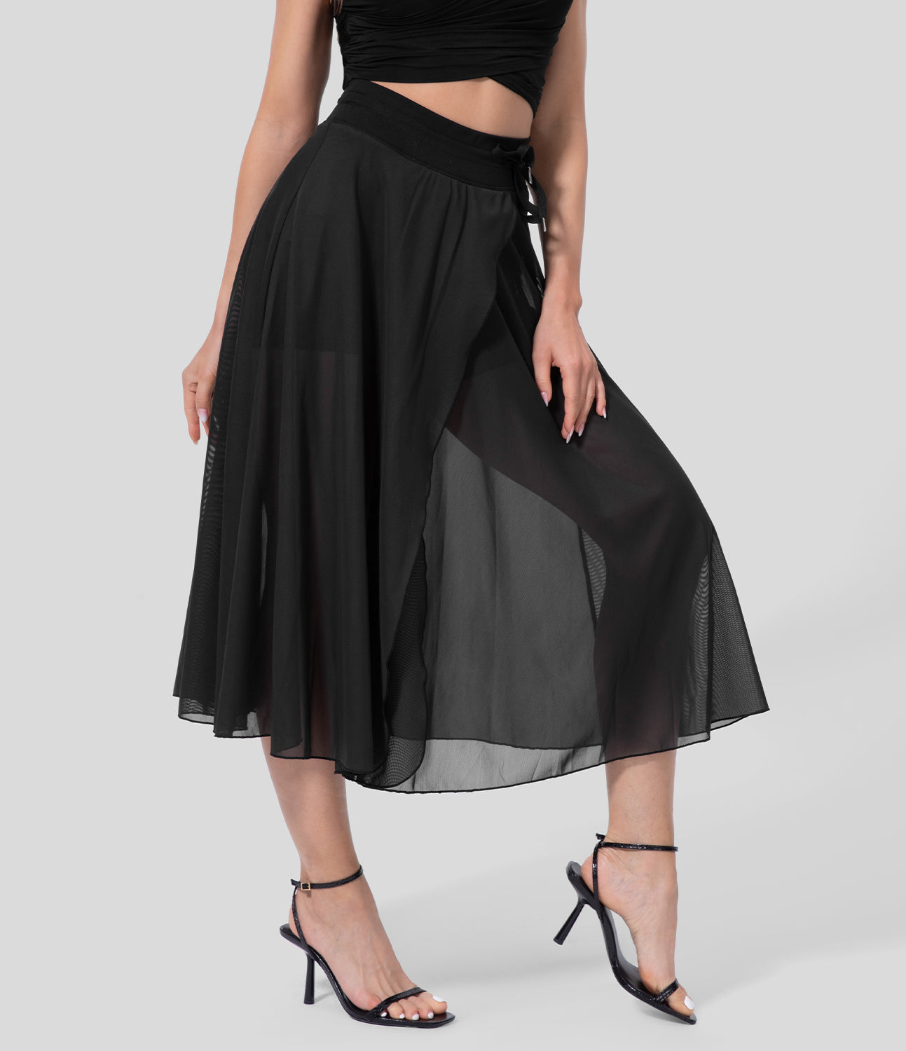 Frau in schwarzem, transparentem Maxirock und High Heels, modisches Outfit, elegante Damenmode, stilvolle Kleidung, Sommerlook.