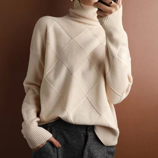 Beiger Rollkragenpullover mit Rautenmuster, kombiniert mit grauer Hose. Modischer Strickpullover für Damen, ideal für Herbst und Winter.