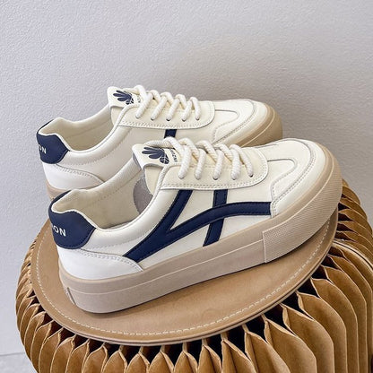Weiße Sneaker mit blauen Details auf Wellpappe, modische Turnschuhe, bequeme Freizeitschuhe, trendige Damen- und Herrenschuhe, stilvolles Design.