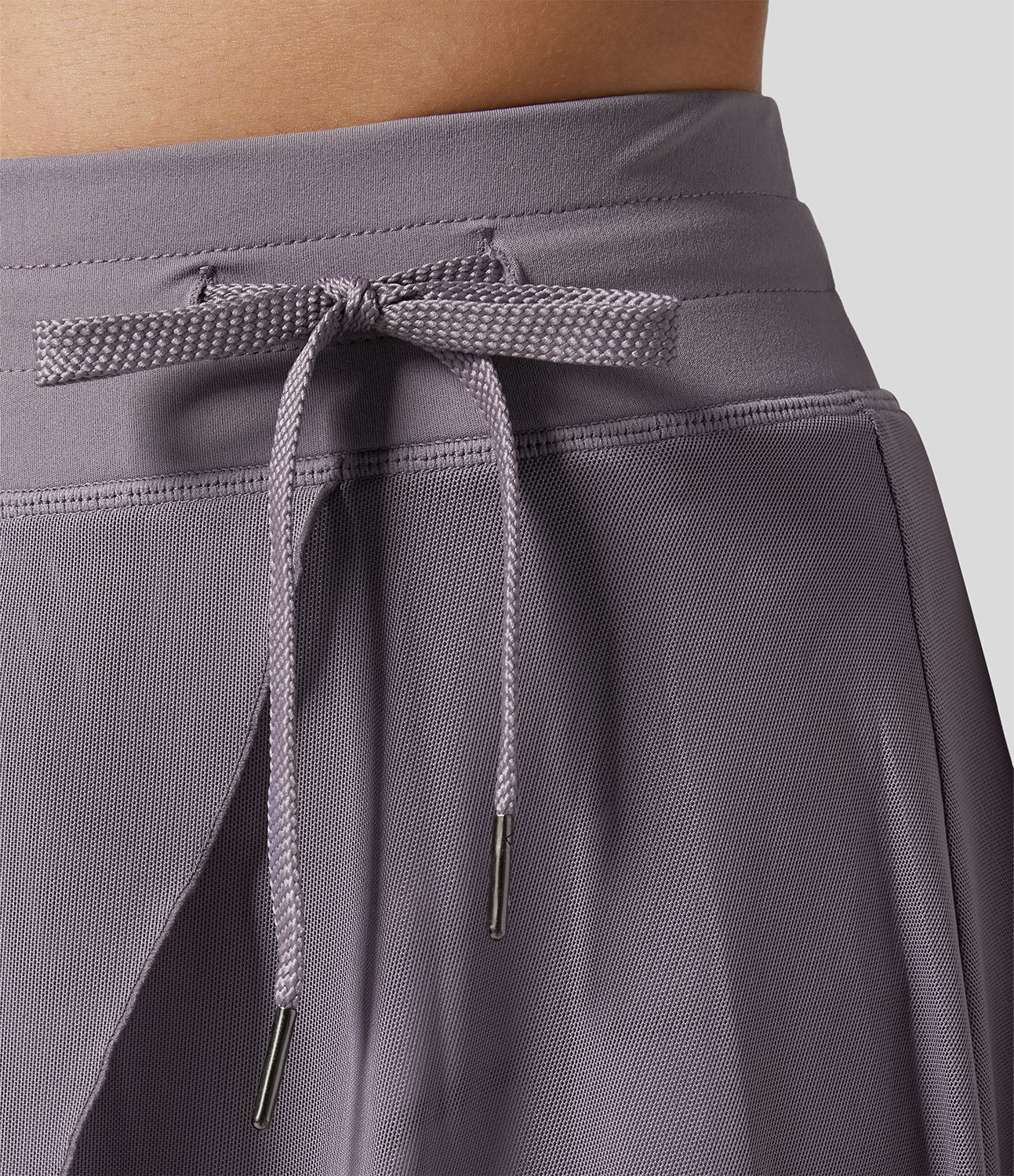Lila Sportrock mit Kordelzug, Nahaufnahme. Bequemer, atmungsaktiver Stoff, ideal für Fitness und Freizeit. Moderner, funktionaler Stil.