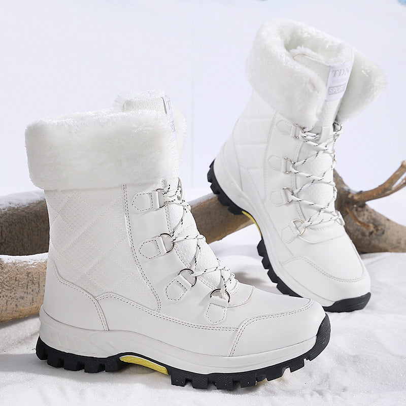 Weiße Damen-Winterstiefel mit Kunstfell, robustem Profil und Schnürung auf schneebedecktem Hintergrund. Ideal für kaltes Wetter und Outdoor-Aktivitäten.
