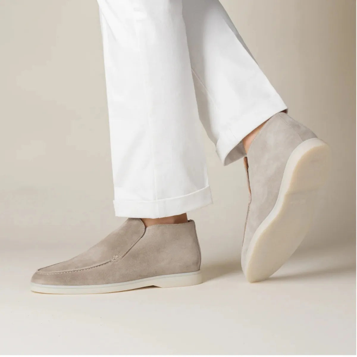 Beige Wildleder-Stiefeletten für Herren, kombiniert mit weißen Hosen. Elegante, bequeme Schuhe, ideal für modische Freizeit- und Business-Outfits.