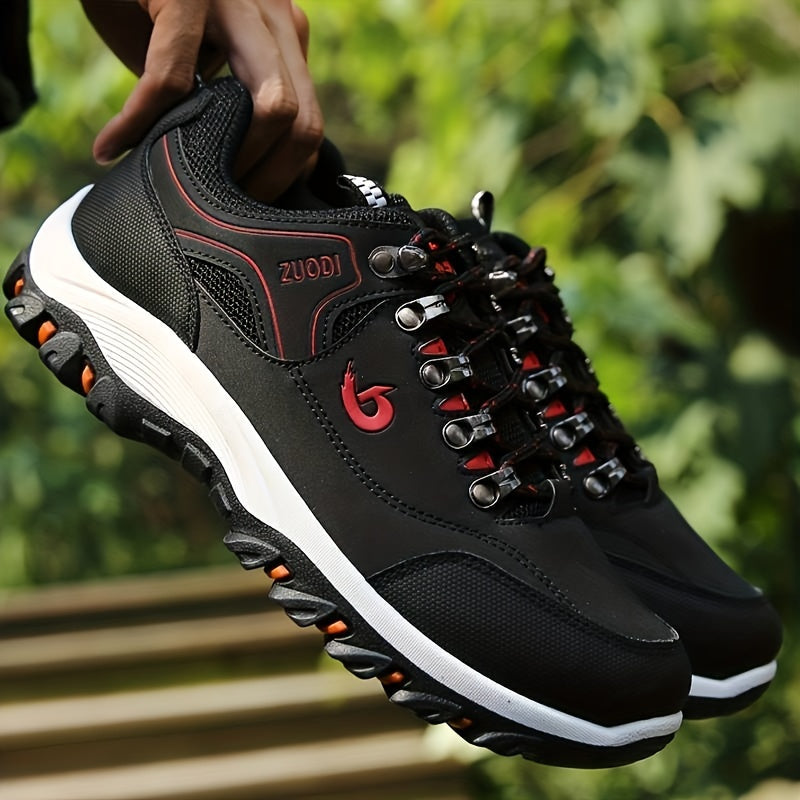 Schwarze Outdoor-Wanderschuhe mit robustem Profil, rotem Logo und Schnürsenkeln. Ideal für Trekking und Abenteuer. Hochwertige Materialien.