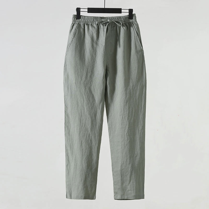 Graue Leinenhose mit elastischem Bund und Kordelzug, lässiger Stil, ideal für Sommermode, komfortabel und atmungsaktiv, auf weißem Hintergrund.