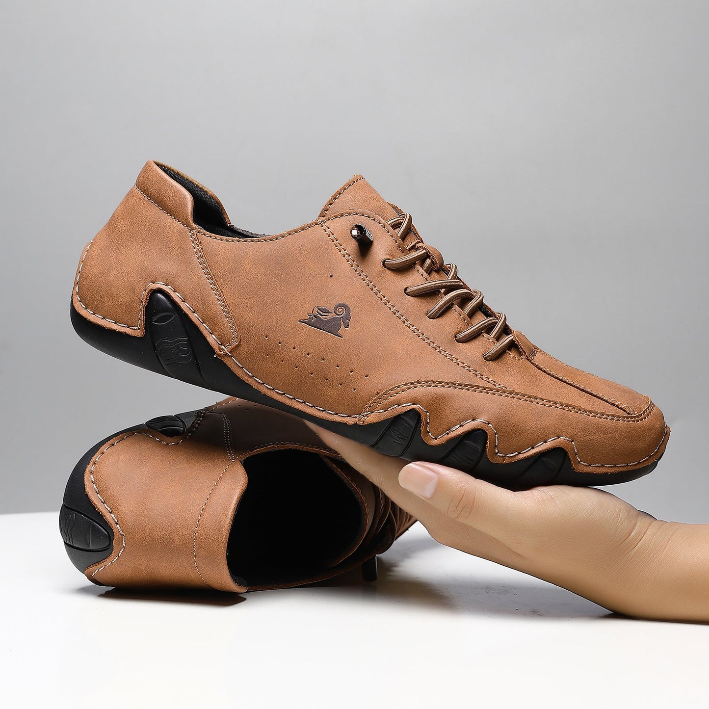 Braune Herrenschuhe aus Leder mit schwarzer Sohle, sportlich-elegantes Design, handgehalten, ideal für Freizeit und Business, komfortabel und stilvoll.