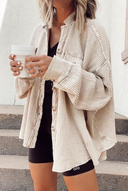 Women's shirt jacket with notch collar, front pockets, and asymmetrical hem