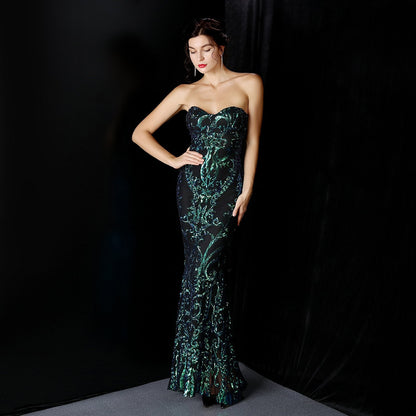 Frau in elegantem, schulterfreiem Abendkleid mit grünem Muster vor schwarzem Hintergrund. Perfekt für Gala, Ball oder Abendveranstaltung.
