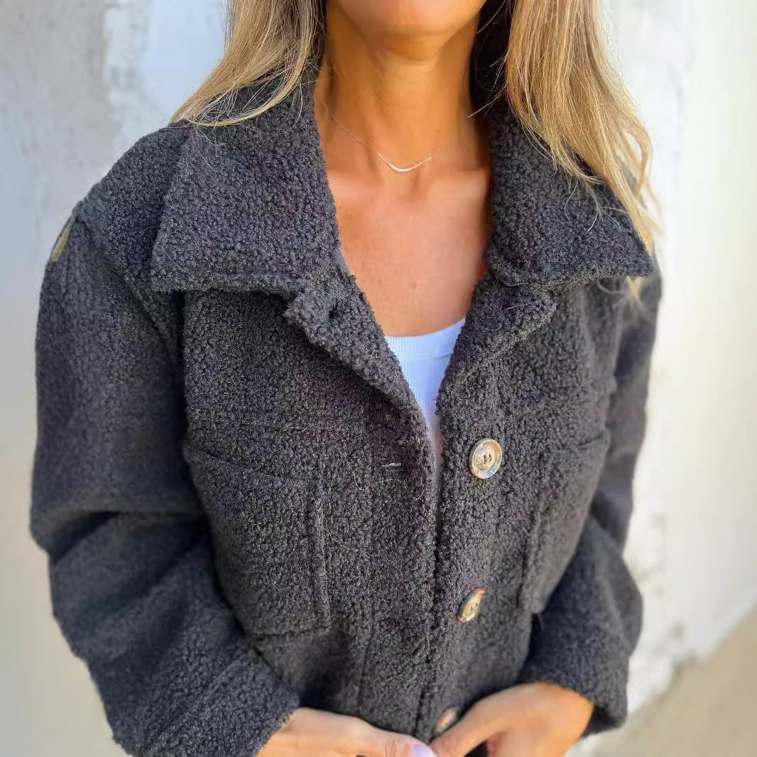 Frau in grauer Teddyjacke mit Knöpfen, modisch und warm, ideal für Herbstmode. Perfekt für stilvolle, gemütliche Outfits.