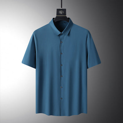 Blaues Herrenhemd mit kurzen Ärmeln, klassischem Kragen und Knopfleiste, auf einem Kleiderbügel vor grauem Hintergrund. Elegante Herrenmode.