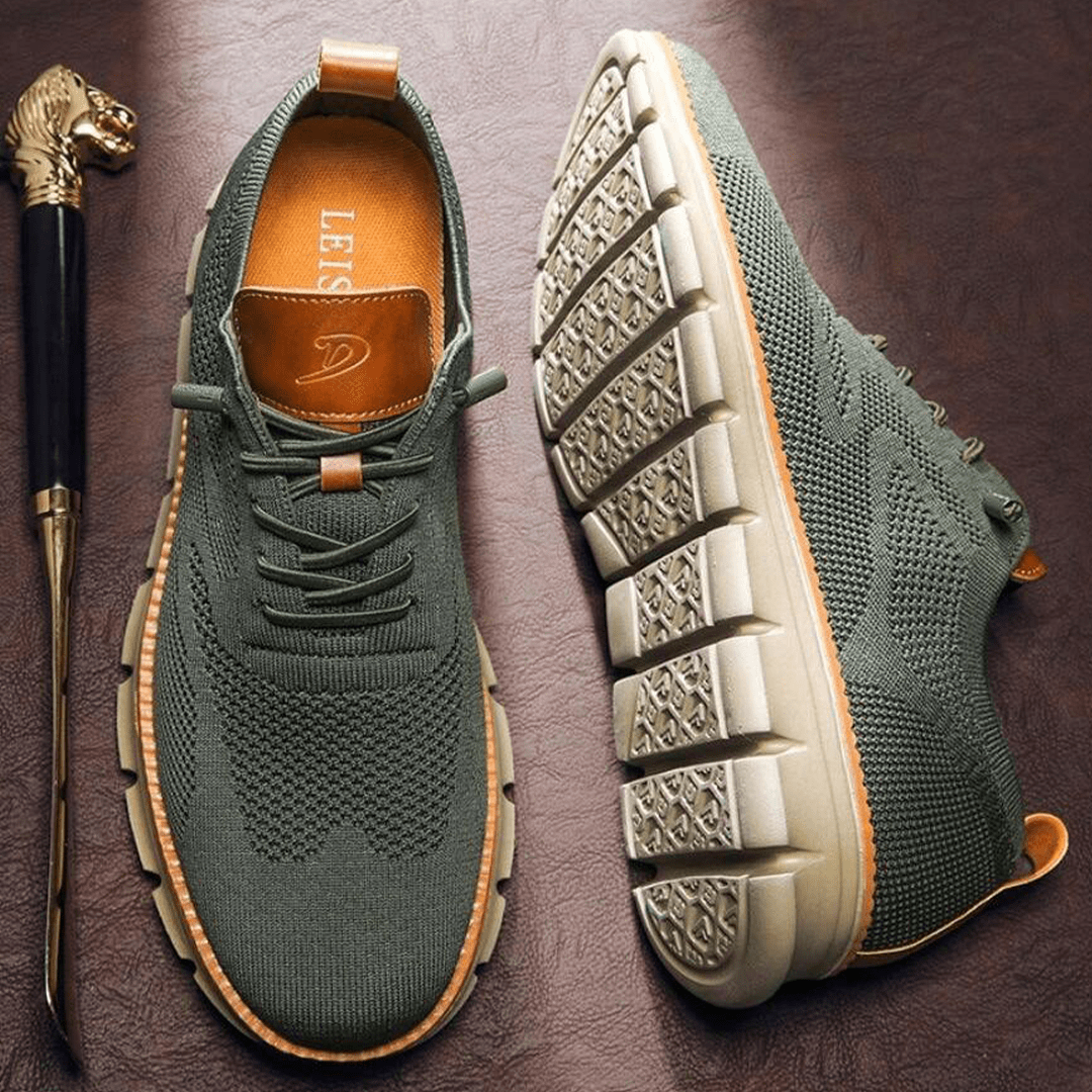 Grüne Herren-Sneaker mit gestricktem Obermaterial und dicker, rutschfester Sohle auf braunem Hintergrund. Bequeme, modische Freizeitschuhe.