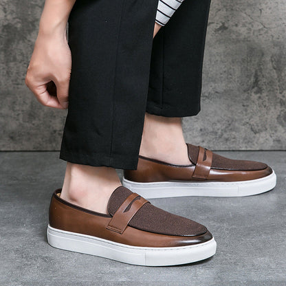 Braune Herren-Sneaker aus Leder mit weißer Sohle, getragen von einer Person in schwarzer Hose. Stilvolle Freizeitschuhe für Männer.
