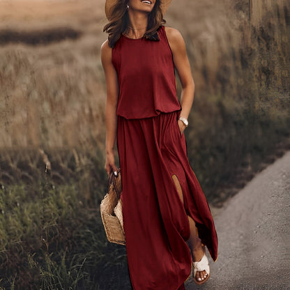 Frau in rotem Maxikleid mit Schlitz, Strohhut und Sandalen auf einem ländlichen Weg. Sommermode, Boho-Stil, Freizeitkleidung.