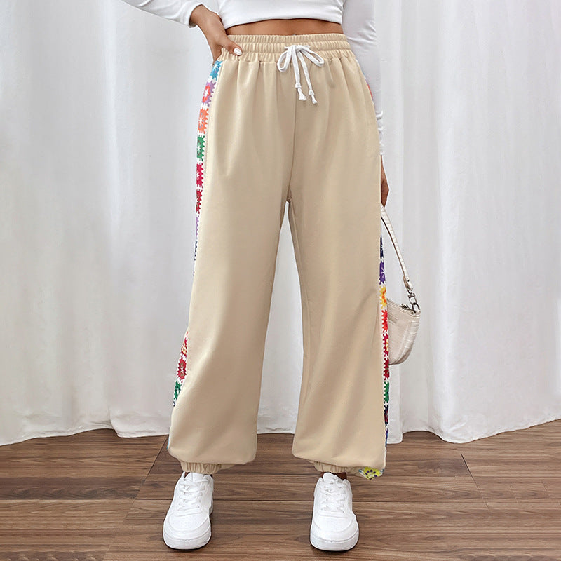 Damen Jogginghose beige mit bunten Streifen, elastischem Bund und Kordelzug. Bequeme Freizeithose, ideal für Sport und Alltag.