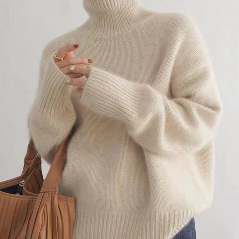 Frau in cremefarbenem Rollkragenpullover aus Wolle hält braune Handtasche. Modetrend, Herbstmode, Strickpullover, Damenbekleidung.