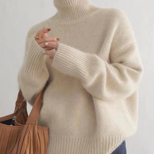 Frau in cremefarbenem Rollkragenpullover aus Wolle hält braune Handtasche. Modetrend, Herbstmode, Strickpullover, Damenbekleidung.