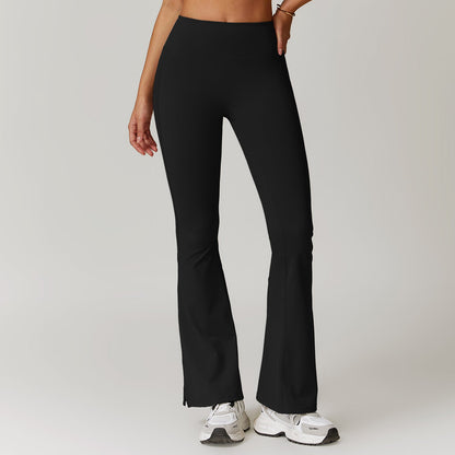 Frau trägt schwarze, ausgestellte Sportleggings und weiße Turnschuhe. Fitnessmode, bequeme Sportbekleidung, trendige Damenleggings.