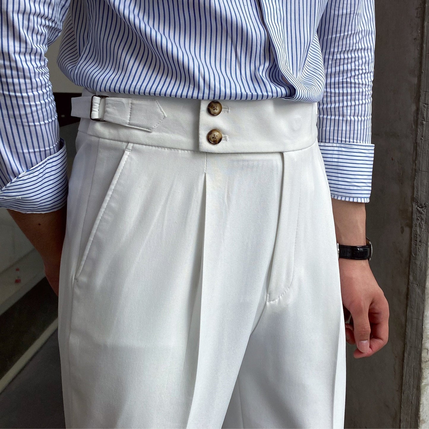 Elegante weiße Anzughose mit doppeltem Bundverschluss, getragen mit gestreiftem Hemd. Stilvolle Herrenmode, Business-Look, klassische Eleganz.