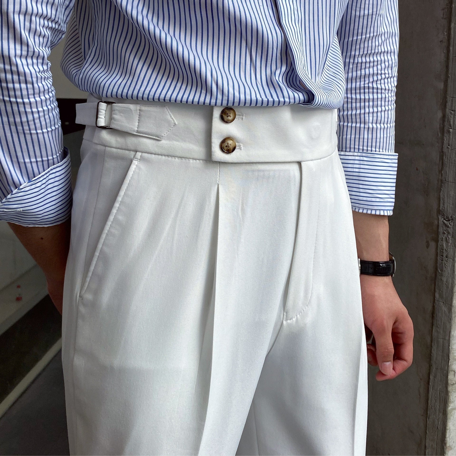 Elegante weiße Anzughose mit doppeltem Bundverschluss, getragen mit gestreiftem Hemd. Stilvolle Herrenmode, Business-Look, klassische Eleganz.