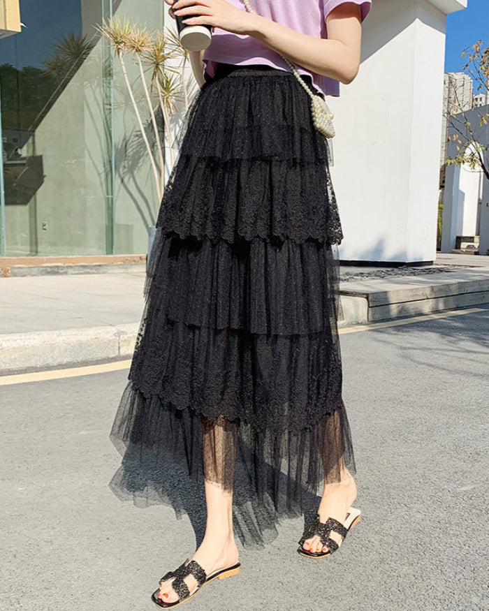 Frau in schwarzem, mehrlagigem Tüllrock und lila Oberteil auf Straße. Modetrend, Sommeroutfit, eleganter Stil, Stadtmode.