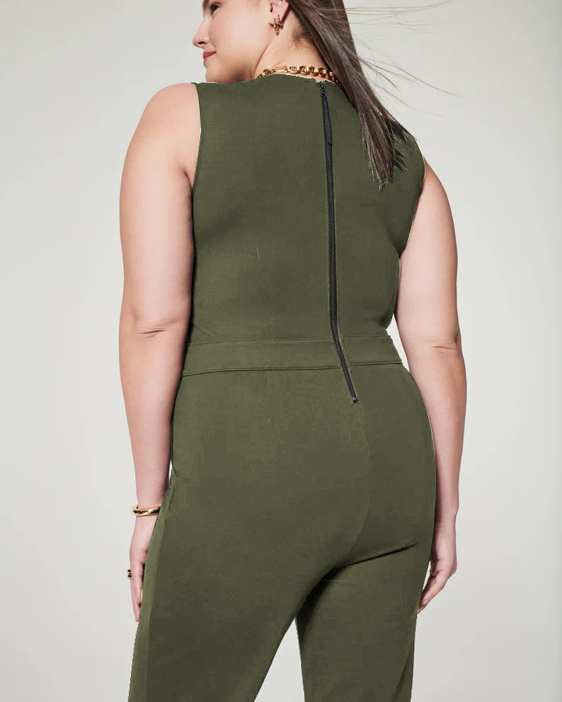 Frau in olivgrünem ärmellosen Jumpsuit mit Reißverschluss hinten, goldene Halskette und Armband, modische Plus-Size-Damenbekleidung.