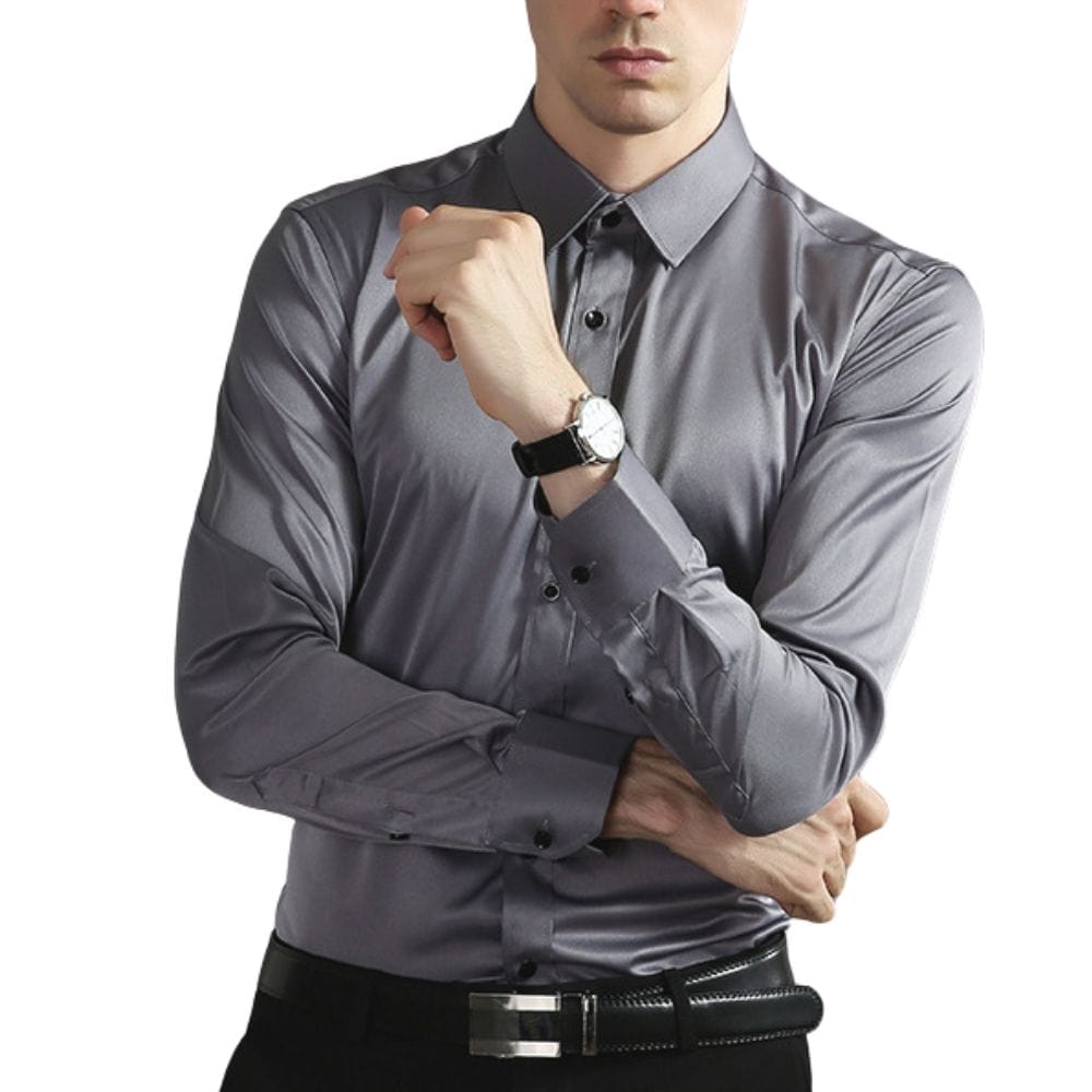 Mann in eleganter, grauer Satin-Hemd, geknöpft, mit schwarzer Uhr und Gürtel. Businessmode, Herrenbekleidung, stilvoller Look.