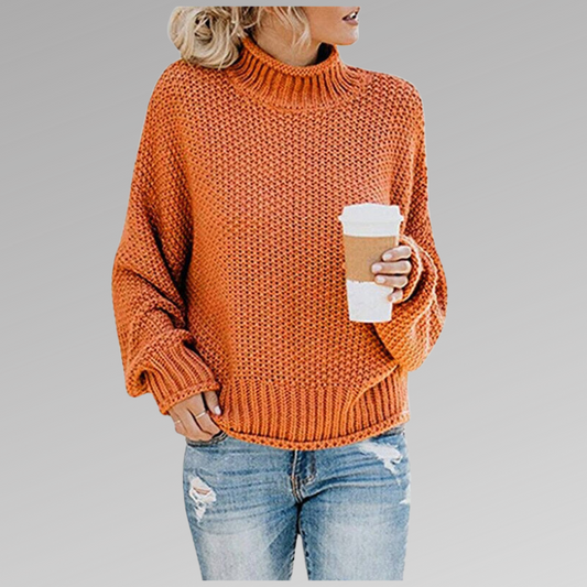 Frau in orangefarbenem Strickpullover hält Kaffeebecher, trägt zerrissene Jeans. Herbstmode, lässiger Stil, gemütlicher Look.