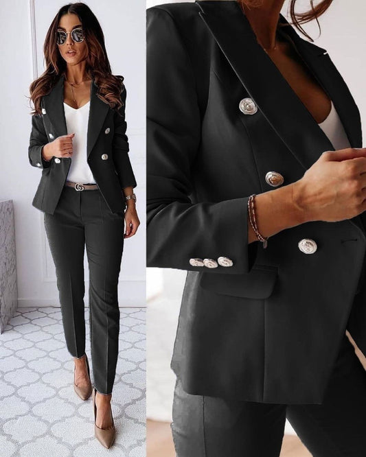 Frau in elegantem, schwarzem Blazer mit silbernen Knöpfen, weißem Top und schwarzer Hose. Businessmode, stilvoll, modern, Damenbekleidung.