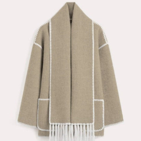 Beigefarbener Wollmantel mit weißen Ziernähten und Fransen, elegantes Design, Damenmode, Herbst-Winter-Kollektion, stilvolle Oberbekleidung.