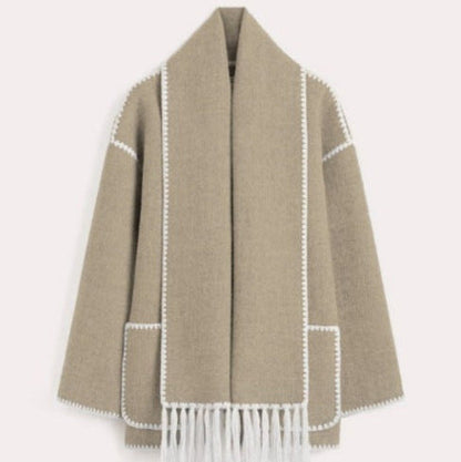 Beigefarbener Wollmantel mit weißen Ziernähten und Fransen, elegantes Design, Damenmode, Herbst-Winter-Kollektion, stilvolle Oberbekleidung.