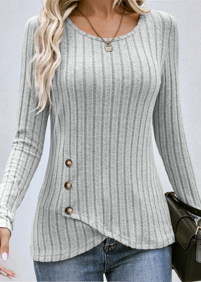 Frau trägt grauen, gestreiften Pullover mit Knopfleiste, kombiniert mit blauer Jeans. Modetrend, Damenmode, Herbstoutfit, lässiger Stil.