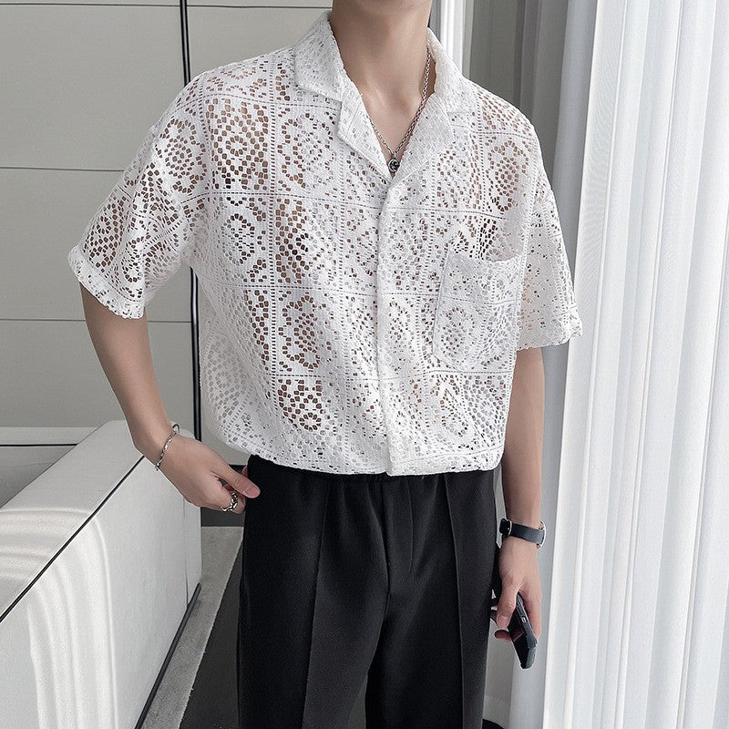 Mann trägt weißes, gehäkeltes Hemd mit kurzen Ärmeln und Kragen, kombiniert mit schwarzer Hose. Elegante, luftige Sommermode für Herren.