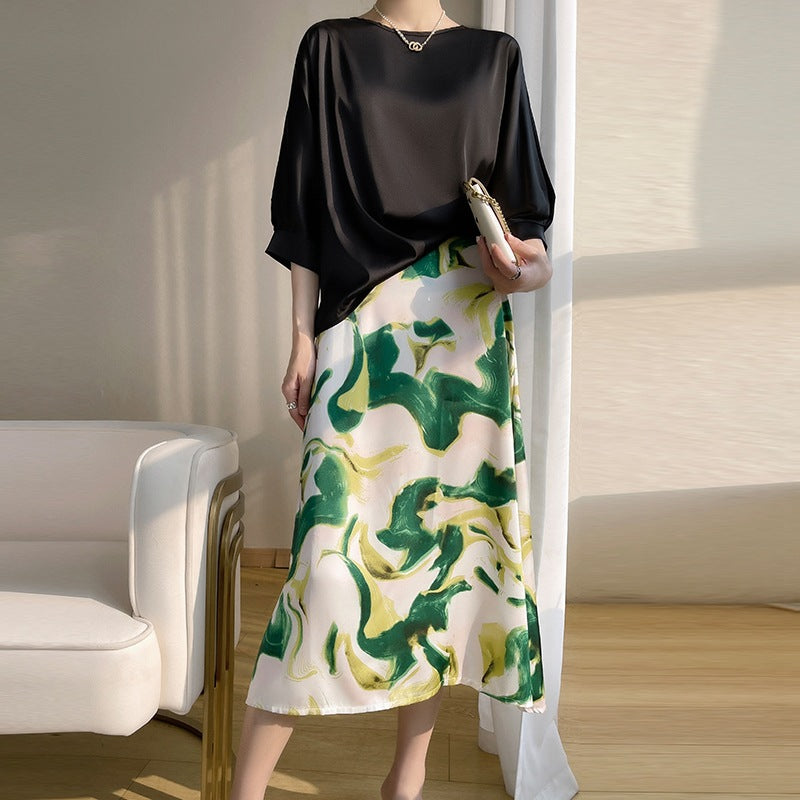 Elegantes Damenkleid mit schwarzem Oberteil und grün-gelbem abstraktem Muster auf weißem Rock, ideal für stilvolle Anlässe und moderne Mode.
