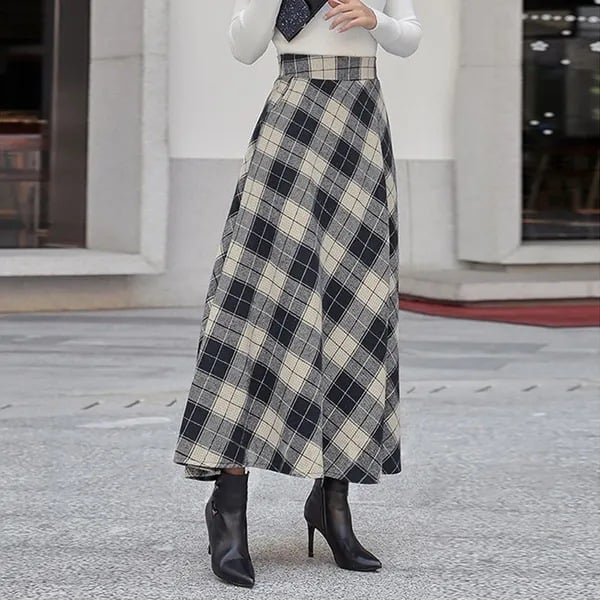 Damenmode: Eleganter, karierter Maxirock in Schwarz-Weiß mit hoher Taille, kombiniert mit schwarzen Stiefeletten. Ideal für Herbstmode und Streetstyle.